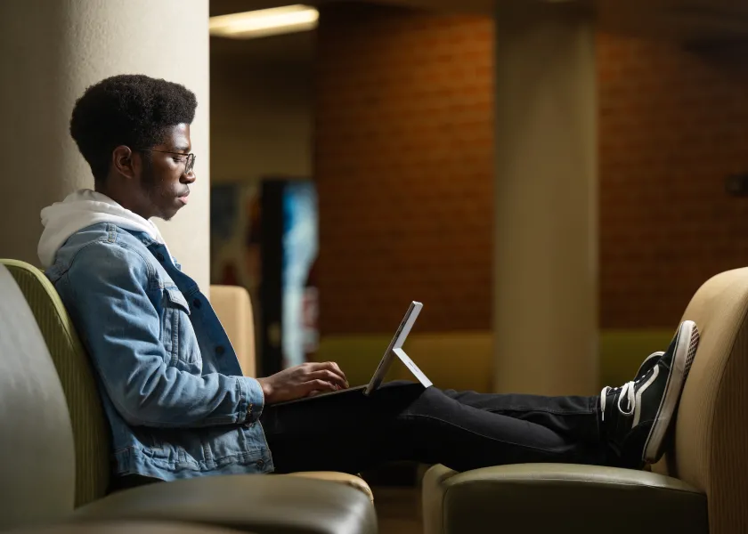student typing on a laptop
