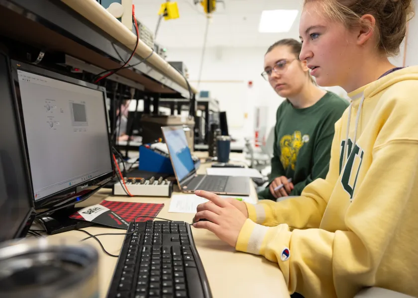 students testing computer hardware at a workbench