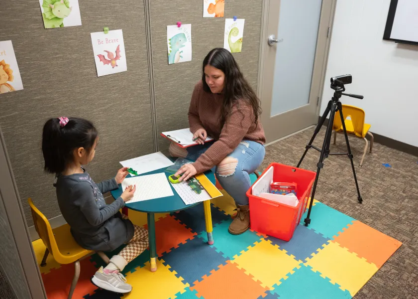 student working with young child in a human development and family science research lab